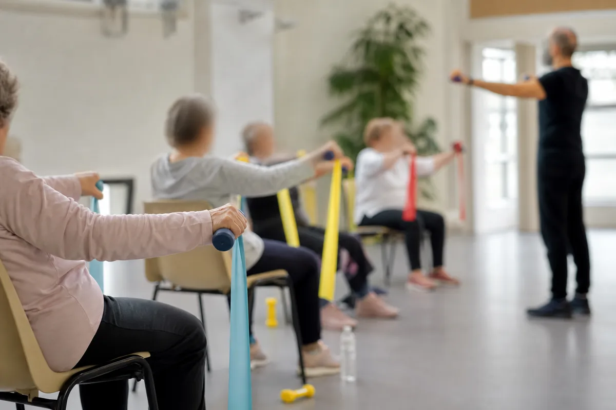 Coach sportif accompagnant un groupe de seniors lors d&rsquo;une séance d&rsquo;activité physique adaptée