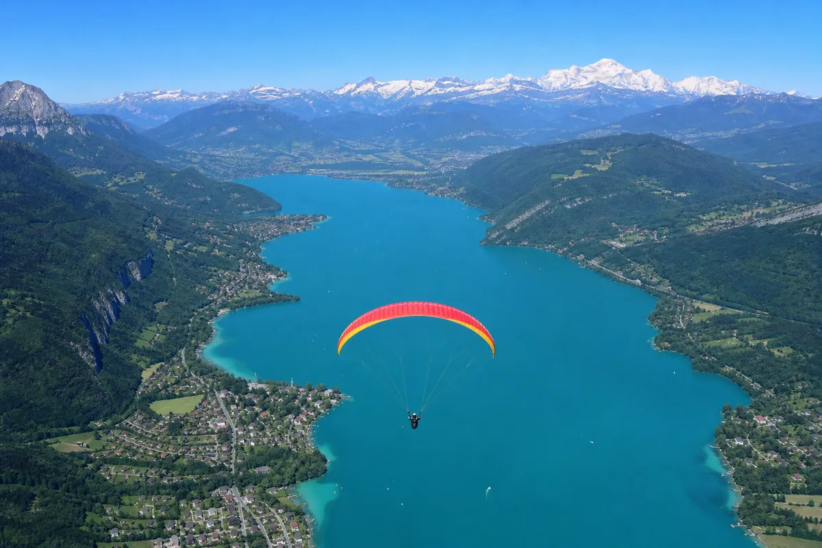 Parachutiste sous voile au-dessus du lac d&rsquo;Annecy avec le Mont Blanc en arrière-plan