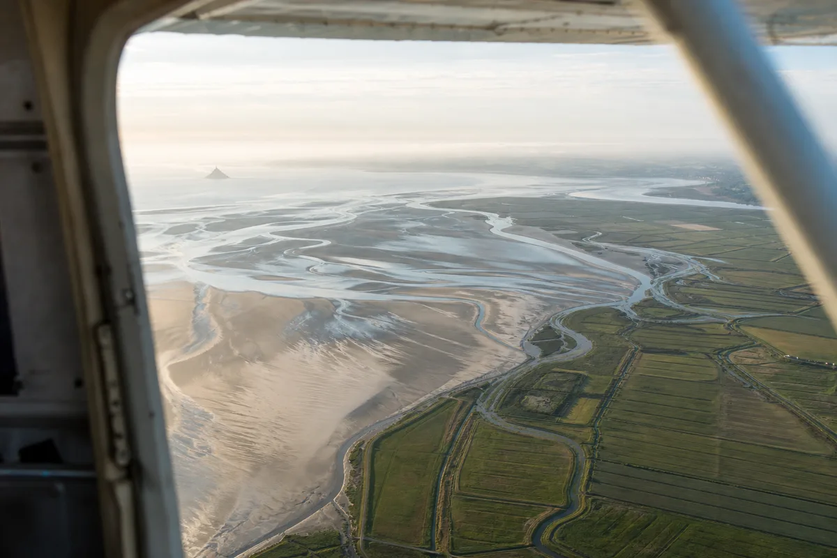 Vue aérienne de la baie du Mont-Saint-Michel et des bancs de sable depuis un avion de parachutage